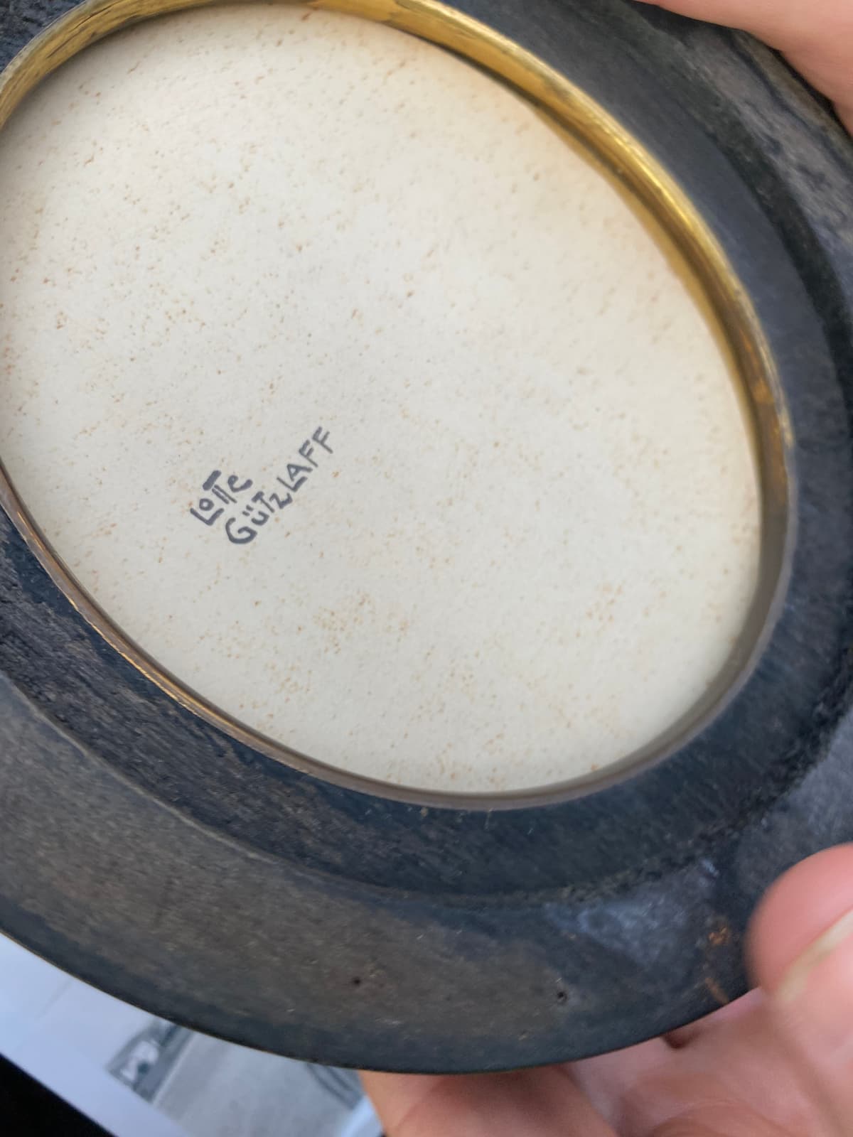 Inside the round case, with the name Lotte Gützlaff